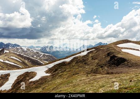 Neve sulle creste dei monti Chugach durante un'estate dell'Alaska con due escursionisti in lontananza; Alaska, Stati Uniti d'America Foto Stock