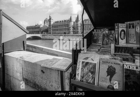 Archivio anni '1990 fotografia in bianco e nero di bouquinistes che vende libri e stampe di antiquariato di seconda mano da una tradizionale scatola verde sulla riva sinistra della Senna, Quai de la Mégisserie, Parigi. È un sito patrimonio dell'umanità dell'UNESCO. Foto Stock