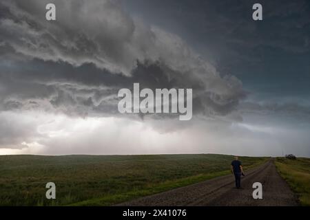 Persona che cammina su una strada mentre un enorme temporale sta attraversando la testa; Stati Uniti d'America Foto Stock