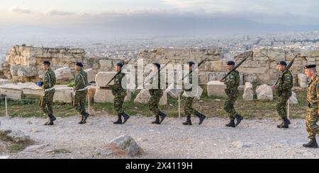 Personale militare che cammina in fila presso l'Acropoli di Atene è un'antica cittadella situata su un affioramento roccioso sopra la città di Atene, in Grecia Foto Stock