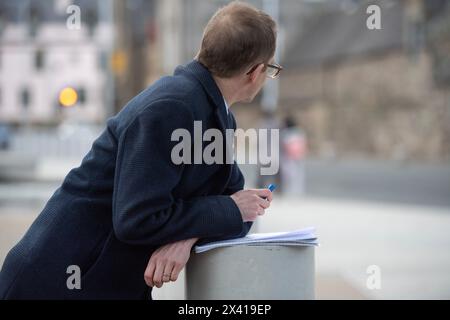 Edimburgo, Scozia, Regno Unito. 29 aprile 2024. NELLA FOTO: Chris Mason, giornalista ed editore politico di BBC News e presentatore del podcast e del programma televisivo Newscast. I team dei media e le squadre di telecamere dal vivo si preparano a trasmettere in diretta al di fuori del Parlamento scozzese il giorno in cui il primo ministro scozzese, Humza Yousaf MSP, annuncia le sue dimissioni all'inizio del pomeriggio. Humza Yousaf ha detto che continuerà ad essere primo ministro, fino a quando non sarà confermato un sostituto. Crediti: Colin Fisher/Alamy Live News Foto Stock