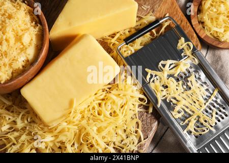 Grattugiato, pezzi interi di formaggio e grattugia sul tavolo, vista dall'alto Foto Stock