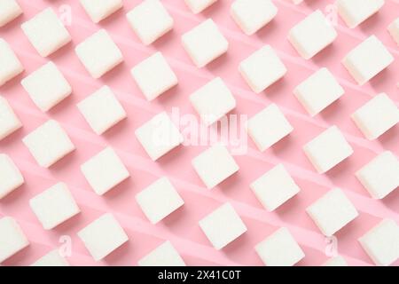 Cubetti di zucchero bianchi su sfondo rosa, vista dall'alto Foto Stock