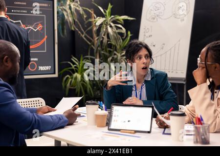 Previsione dei partner che raccolgono statistiche in una conferenza informativa, affrontando le iniziative di differenziazione del marchio per evidenziare i valori organizzativi sul mercato. Team di pubbliche relazioni per lo sviluppo. Foto Stock