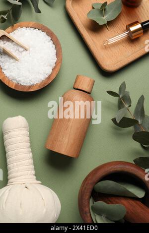 Diversi prodotti aromaterapici e foglie di eucalipto su fondo di oliva, distese piatte Foto Stock