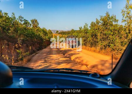 Madagascar 22. 10. 2023 .strada rossa polverosa e fangosa in cattive condizioni con grandi buchi. Le rotte sono estremamente cattive durante la stagione delle piogge in Madagascar. grande vecchio truc Foto Stock