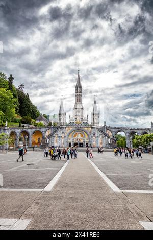 LOURDES - Giugno - 15 - 2019: una croce cristiana su uno sfondo la Basilica di Nostra Signora del Rosario a Lourdes, Francia Foto Stock
