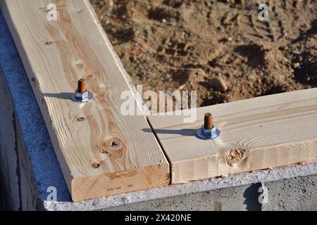 Soglia su ancoraggi di fondazione in calcestruzzo. Tassello filettato per fissare il pannello di legno. Foto Stock