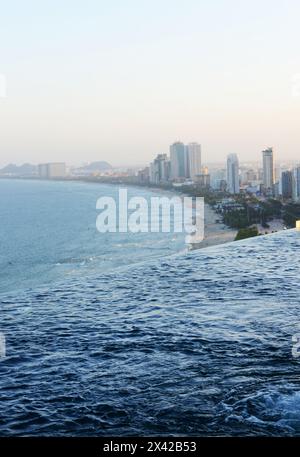 Una splendida vista della costa e del mare con la piscina a sfioro sul tetto dell'Hilton Garden Inn a da Nang, Vietnam Foto Stock