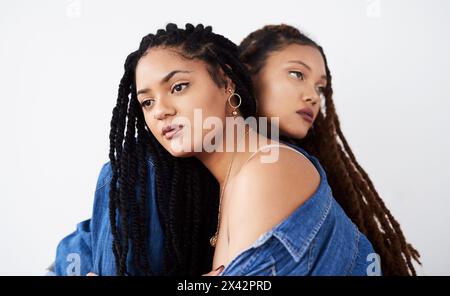 Sorelle, jeans e moda in studio, abiti e stile su sfondo bianco. Donne, amici e cura del rapporto sullo sfondo, casual Foto Stock