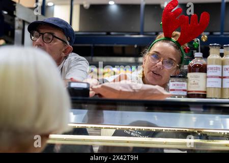 Un cliente acquista cibo da una macelleria nel South Melbourne Market. South Melbourne, Victoria, Australia. Foto Stock