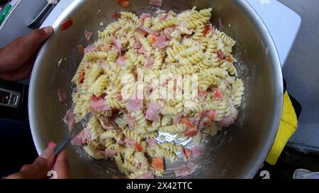 Spaghetti di pasta con salsa di formaggio cremoso e piccoli pezzi di prosciutto Foto Stock