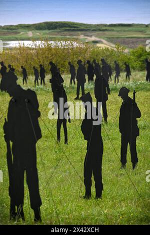 Una vista delle sagome Standing with Giants che creano il per la vostra installazione di domani al British Normandy Memorial, a Ver-Sur-Mer, in Francia, in occasione del 80° anniversario del D-Day. Le 1.475 statue onorano ciascuno dei militari caduti il D-Day stesso e si trovano all'ombra del monumento che si affaccia su Gold Beach, dove molte di esse sbarcarono quasi 80 anni fa. Ver-Sur-Mer, Calvados, Francia il 27 aprile 2024. I campi all'interno del campus del British Normandy Memorial sono stati riempiti di sagome di militari che rappresentano i tre servizi militari, ognuno in piedi appena sotto la t Foto Stock