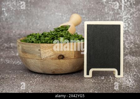 Adattogeni di prezzemolo verde fresco essiccato con mockup modello spazio copia lavagna vuota. Erboristeria mangiare sano. Cibo prebiotico superfood. Erbe biologiche coltivate in casa sostenibili Foto Stock