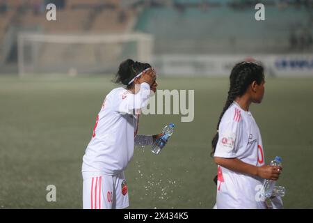 I giocatori del Dhaka Rangers FC sorseggiano dell'acqua durante una pausa rinfrescante per evitare il surriscaldamento durante la partita della UCB Women's Football League contro Siraj Sriti Sangsa Foto Stock