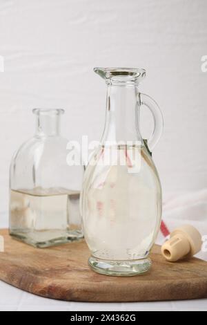 Aceto nella caraffa di vetro e bottiglia sul tavolo Foto Stock
