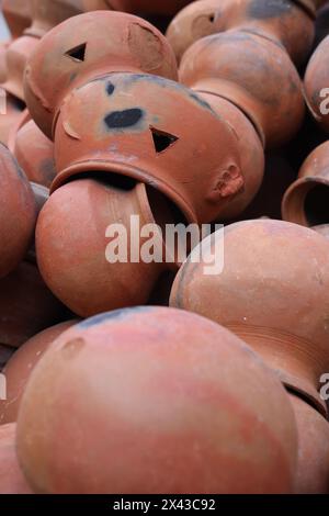 le pentole sono raccolte e disposte in uno schema nello spazio vuoto. Il vasaio lavora su una ruota di ceramica realizzata in argilla dai colori tenui, in stile retrò con tonalità Cl Foto Stock