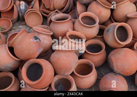 le pentole sono raccolte e disposte in uno schema nello spazio vuoto. Il vasaio lavora su una ruota di ceramica realizzata in argilla dai colori tenui, in stile retrò con tonalità Cl Foto Stock