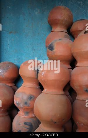 le pentole sono raccolte e disposte in uno schema nello spazio vuoto. Il vasaio lavora su una ruota di ceramica realizzata in argilla dai colori tenui, in stile retrò con tonalità Cl Foto Stock