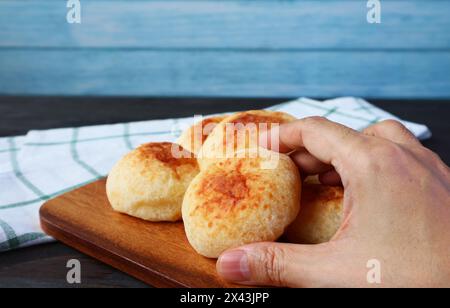 Primo piano per raccogliere un pane al formaggio brasiliano appena sfornato o un Pao de Queijo Foto Stock
