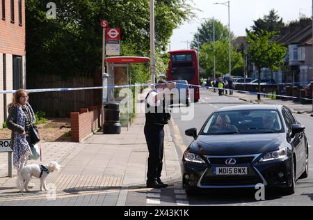 La polizia ha parlato con i membri del pubblico sulla scena di Hainault, a nord-est di Londra, dopo aver riferito di diverse persone accoltellate in una stazione della metropolitana. Un uomo di 36 anni con una spada è stato arrestato a seguito dell'attacco a membri del pubblico e a due agenti di polizia. Data foto: Martedì 30 aprile 2024. Foto Stock