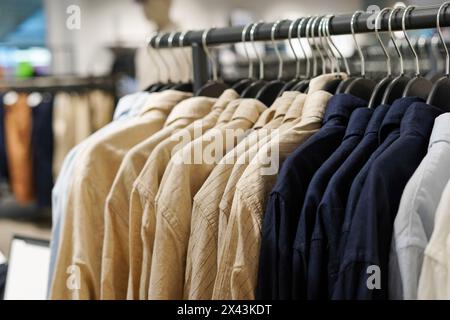 Camicie da uomo su grucce in un negozio di abbigliamento da vicino Foto Stock