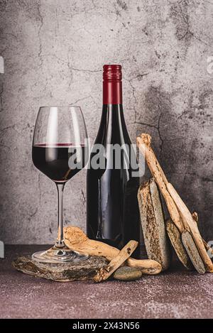 Fotografia di bevande di vino rosso; rosso; vino; bicchiere di vino; bottiglia; vintage; retrò; invecchiato; pietra; legno; cemento; cantina; background; celebrazione; romanticismo; ba Foto Stock