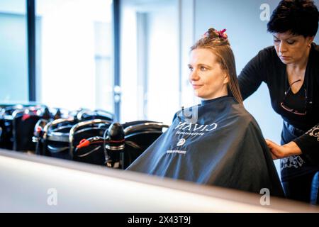 Berlino, Germania. 22 aprile 2024. Valentyna Vysotska, parrucchiere Ucraina, taglia i capelli della sua cliente, fotografata al salone di parrucchiere Coiffeur Sivan di Berlino, 22 aprile 2024. Credito: dpa/Alamy Live News Foto Stock