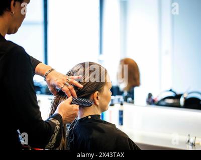 Berlino, Germania. 22 aprile 2024. Un parrucchiere pettina i capelli del suo cliente, fotografato al parrucchiere Coiffeur Sivan di Berlino, 22 aprile 2024. Credito: dpa/Alamy Live News Foto Stock