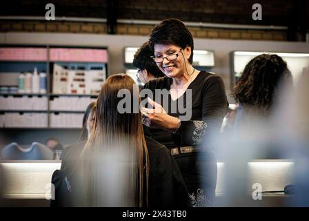 Berlino, Germania. 22 aprile 2024. Valentyna Vysotska, parrucchiere Ucraina, taglia i capelli della sua cliente, fotografata al salone di parrucchiere Coiffeur Sivan di Berlino, 22 aprile 2024. Credito: dpa/Alamy Live News Foto Stock