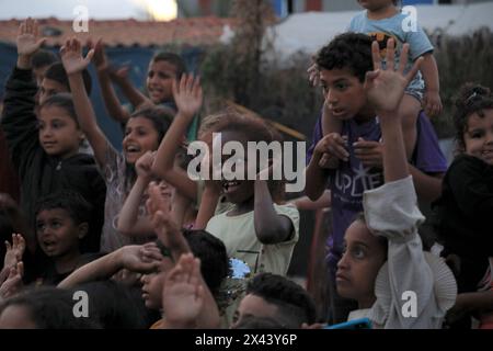 (240430) -- RAFAH, 30 aprile 2024 (Xinhua) -- i bambini guardano i cartoni animati in un campo temporaneo nella città meridionale della Striscia di Gaza, Rafah, 29 aprile 2024. (Foto di Rizek Abdeljawad/Xinhua) Foto Stock