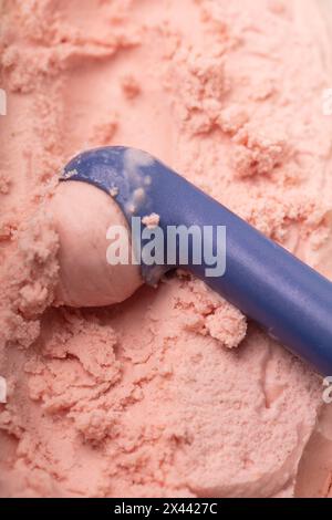 Servire una paletta di gelato alle fragole fatto in casa con una paletta per gelato dall'alto Foto Stock
