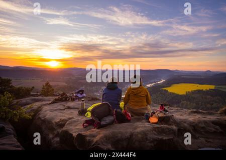 Sächsische Schweiz Sonnenaufgang auf dem Lilienstein. Der Lilienstein ist der markanteste und bekannteste Felsen im Elbsandsteingebirge. Blick ins Elbtal nach Bad Schandau. Touristen und Touristinnen geniessen ein Sonnenaufgangsfrühstürck hoch über der Elbe. Ebenheit Sachsen Deutschland *** la Svizzera sassone sorge sul Lilienstein il Lilienstein è la roccia più suggestiva e più conosciuta dell'Elba Montagne di arenaria Vista sulla valle dell'Elba per i turisti di Bad Schandau gustatevi una colazione all'alba sopra l'Elba Ebenheit Sassonia Germania Foto Stock