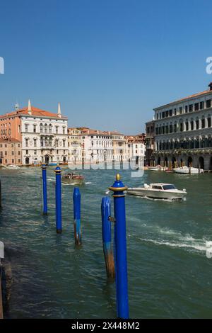 Pali d'ormeggio blu e taxi d'acqua sul Canal grande con palazzi residenziali in stile architettonico rinascimentale, quartiere San Polo, Venezia Foto Stock