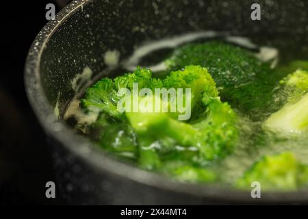 broccoli freschi in acqua bollente in una padella, cibo sano, vista dall'alto Foto Stock