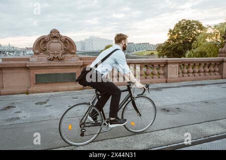 Lunghezza completa del percorso ciclistico professionale per uomini d'affari su un sentiero pedonale in città Foto Stock