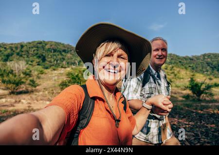 Ritratto di una donna anziana felice che fa selfie con un uomo in vacanza Foto Stock