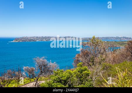 Vista sulla macchia, l'oceano e il sobborgo di Sydney dal punto panoramico di Dobroyd Head, Sydney, Australia Foto Stock