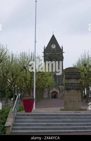 Sainte-Mere-Eglise, Francia - 19 aprile 2024: Chiesa di Sainte-Mere-Eglise. Gente che cammina a Sainte-Mere-Eglise. Strade ed edifici. Uno stile di vita nel nostro Foto Stock