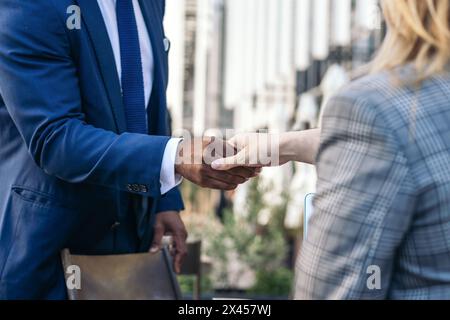 Due irriconoscibili uomini d'affari multirazziali che stringono la mano per chiudere un accordo d'affari Foto Stock