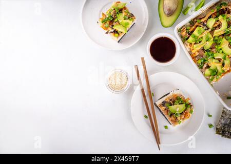 Philadelphia Sushi Bake ricetta casseruola a base di riso, formaggio cremoso, trota di salmone, alghe, avocado, salsa, cipolla verde. Servito con nori di canna tostata Foto Stock