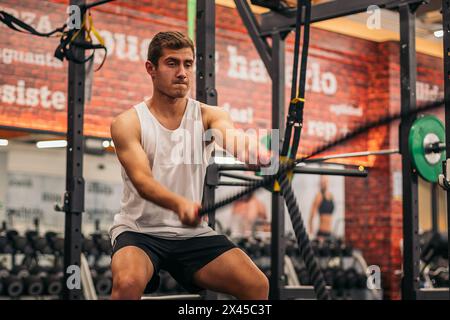 atleta uomo allenarsi con le corde in palestra Foto Stock