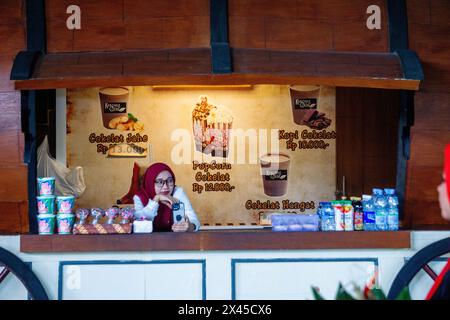 Felice negoziante indonesiano in un negozio di alimentari, in attesa di un cliente Foto Stock