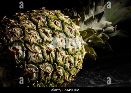 ananas su sfondo di legno nero Foto Stock