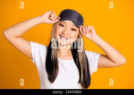 Foto di una bella donna carina che indossa un pigiama bianco alla moda isolato su sfondo giallo Foto Stock