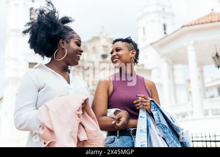 Donne nere amici alla moda che si divertono a camminare per strada Foto Stock
