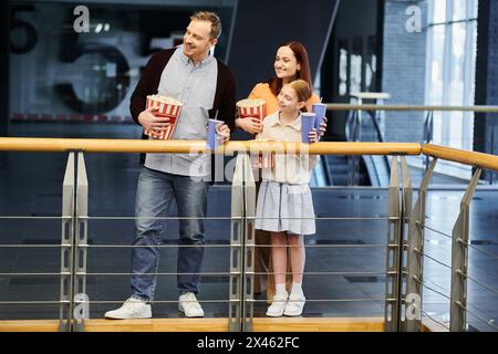 Padre madre e figlia osservano la città da un balcone, godendosi un momento speciale insieme come una famiglia felice. Foto Stock