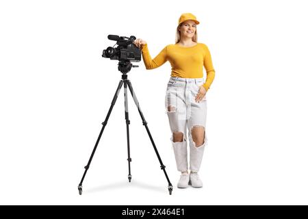 Ritratto completo di un operatore di una donna con una fotocamera su un cavalletto isolato su sfondo bianco Foto Stock
