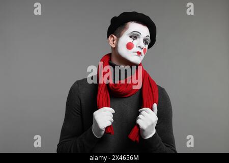 Ritratto dell'artista mimo in berretto su sfondo grigio Foto Stock