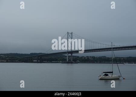 Splendida vista sul Forth Road Bridge con una piccola barca di fronte. Il ponte ricorda un po' Golden Gates a San Francisco. Foto Stock